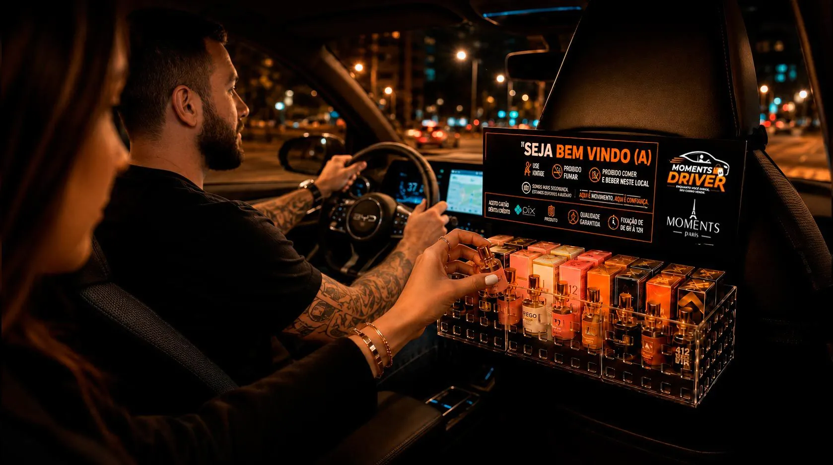 Motorista de aplicativo mostrando o display de perfumes para o passageiro no banco de trás, para vender perfume no Uber